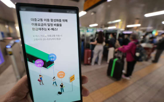 A user holds a mobile screen of the K-pass, Korea's new public transportation fare refund service. [YONHAP]