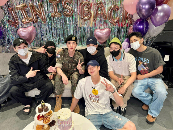 Members of boy band BTS pose for photos after greeting member Jin on the day he was discharged from his year and a half of military service on June 12. [BIGHIT MUSIC]