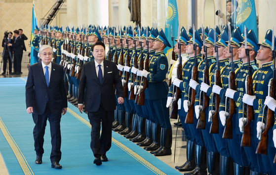 President Yoon Suk Yeol, right, and Kazakh President Kassym-Jomart Tokayev inspect an honor guard during an official welcoming ceremony at the presidential palace in Astana, Kazakhstan, Wednesday, ahead of their bilateral summit. [JOINT PRESS CORPS]