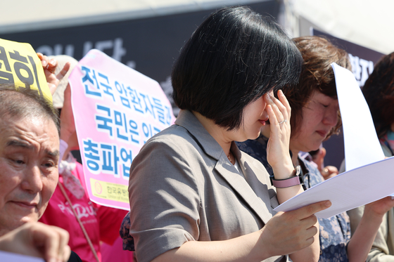 The Korea Severe Disease Association and other patients’ groups hold up placards calling on doctors to cancel a nationwide strike planned for June 18 during a protest in front of the National Assembly on Thursday. [YONHAP]