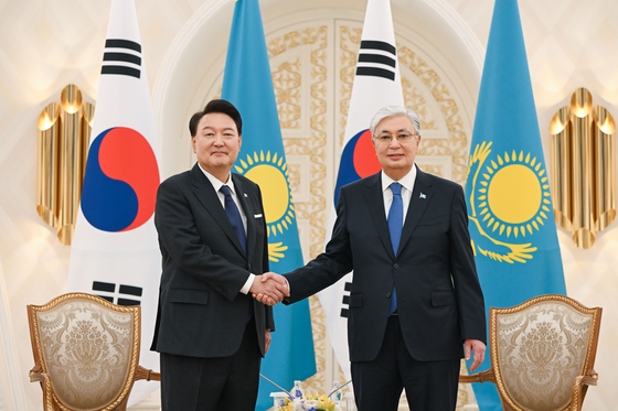 President Yoon Suk Yeol, left, and Kazakh President Kassym-Jomart Tokayev shake hands at their bilateral summit at the presidential palace in Astana, Kazakhstan, Wednesday. [JOINT PRESS CORPS]