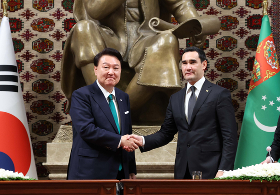 Korean President Yoon Suk Yeol, left, and Turkmen President Serdar Berdimuhamedow shake hands during a joint press briefing on the results of their bilateral summit in Ashgabat, Turkmenistan, Monday. [JOINT PRESS CORPS]