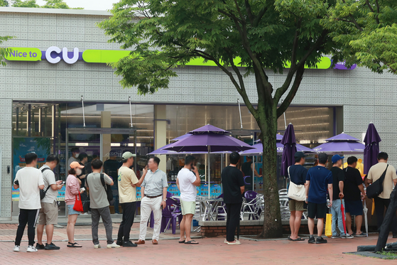 Customers line up for an event held at a CU convenience store in June 2023. [YONHAP] 