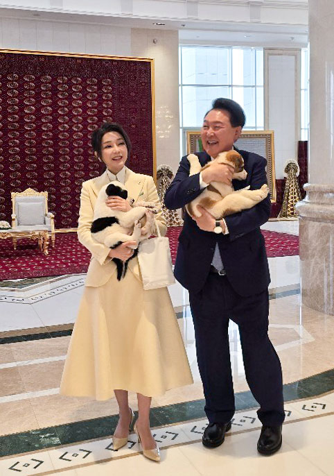 Korean President Yoon Suk Yeol, right, and first lady Kim Keon Hee, hold Turkmenistan’s national dog breed, a Central Asian shepherd known as the Alabai, after their luncheon with former Turkmen President Gurbanguly Berdimuhamedow in Ashgabat, Turkmenistan, on Tuesday. [JOINT PRESS CORPS]