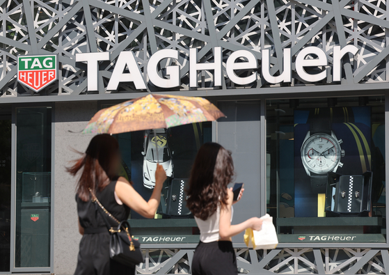 Passersby walk in front of a TAG Heuer store in Seoul on Sunday. [YONHAP] 