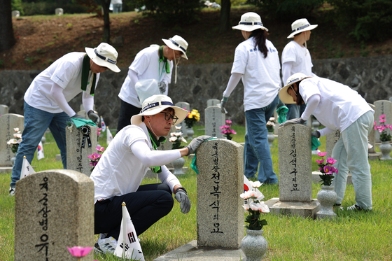 HD Hyundai employees participate in a volunteer program to tend gravesites at Seoul National Cemetery in southern Seoul. [HD HYUNDAI]
