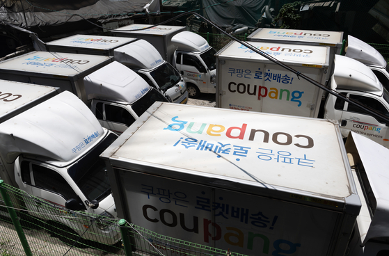 Coupang delivery trucks are parked in Seoul on Thursday. Korea's Fair Trade Commission announced its decision to fine Coupang 140 billion won over the e-commerce giant's alleged search manipulation practices on the same day. [YONHAP]