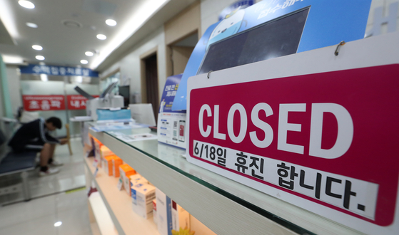 A notice informing patients of the clinic's closure on Tuesday is placed on a desk in a private clinic in Gyeonggi on Monday. [NEWS1] 
