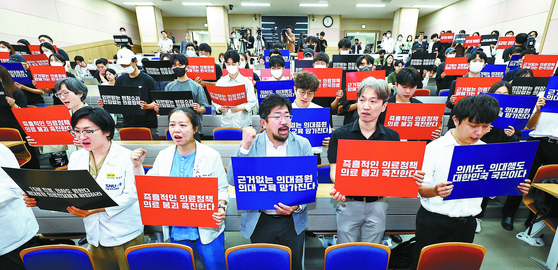 Medical professors and junior doctors at Seoul National University Hospital and medical students studying at Seoul National University's College of Medicine participate in a protest at the school's building in Jongno District, central Seoul on Monday. [KIM JONG-HO]