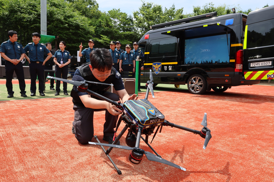 An official from the Gwanak Police Station demonstrates using a flight patrol drone for crime prevention at the Mokgolsan Trail in Gwanak District, southern Seoul, on Monday. This is the first time that drones are being used by police agencies in Seoul for crime prevention. [YONHAP]