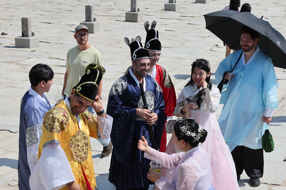 Tourists at central Seoul's Gyeongbok Palace wearing Korean traditional dress hanbok on June 13. [YONHAP]
