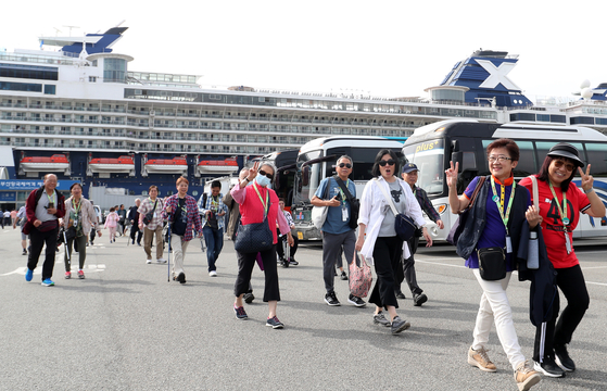 Tourists get off from the Celebrity Millenium cruise ship on May 22 in Busan. [NEWS1]