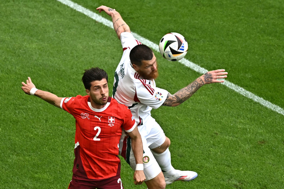 Switzerland defender Leonidas Stergiou, left, fights for the ball with Hungary forward Martin Adam during their Euros group stage match in Cologne, Germany on June 15. [AFP/YONHAP]