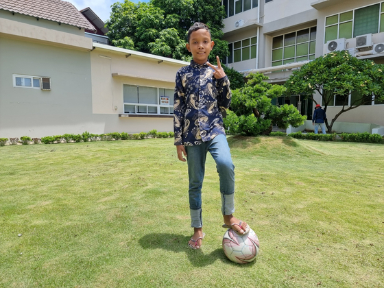 Aok Rotha, who has long suffered from a congenital heart disease, dribbles a ball in a yard at Hebron Medical Center in Phnom Penh, Cambodia, on June 4. Rotha received heart surgery in 2018 but was unable to afford follow-up surgery due to his family's economic hardship. During the Cambodian visit, first lady Kim Keon Hee visited a hospital and the boy's home and discussed ways to provide treatment. [JOONGANG ILBO] 