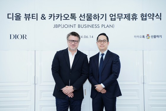 Nicolas Bernard-Bouissieres, President of Parfums Christian Dior and CEO of LVMH’s beauty division in Korea, left, and Jun Sung-joon, head of Kakao Commerce, pose at a signing ceremony in Dior Beauty Korea's office building in central Seoul on Friday. [KAKAO]