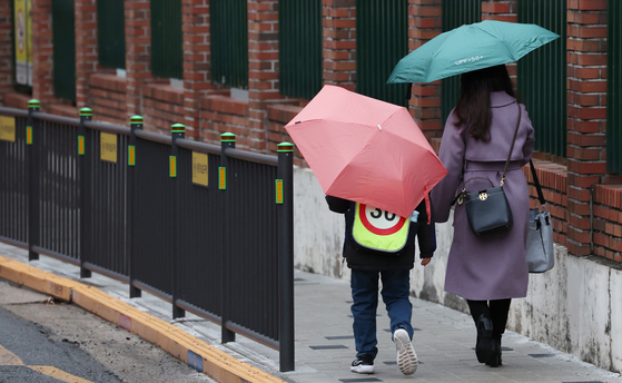 An elementary school student and a parent walk to school in Seoul on February 5. [NEWS1]