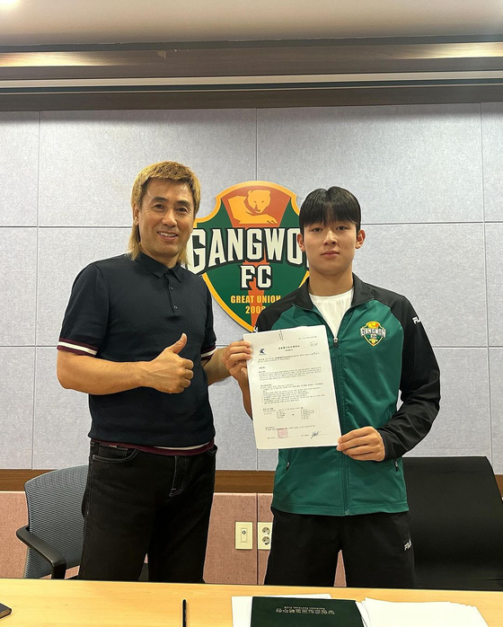 Gangwon FC midfielder Yang Min-hyuk, right, poses with Gangwon FC President Kim Byung-ji after signining a pro contract in a photo shared on the club's official Instagram account on Monday. [SCREEN CAPTURE]