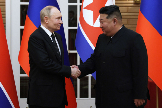 North Korean leader Kim Jong-un and Russian President Vladimir Putin shake hands after a welcoming ceremony at Kim Il Sung Square in Pyongyang on Wednesday. [AFP/YONHAP]