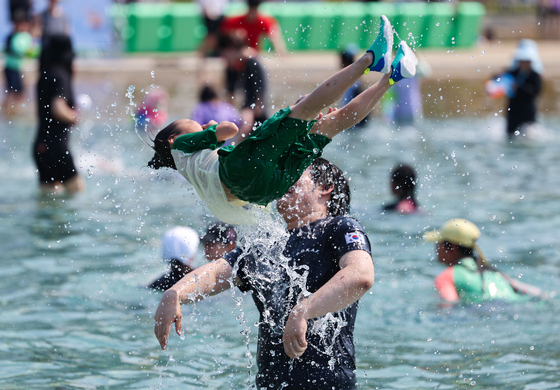 A father and daughter enjoy the outdoor pool at the Jamsil Hangang Park in Songpa District, southern Seoul, during the pool’s opening event held on Wednesday, one day prior to the official opening of six river park pools run by the Seoul Metropolitan Government. [YONHAP] 
