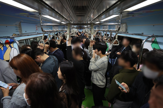 Commuters stand in a seatless subway car on line No. 7 on Sunday. [YONHAP] 