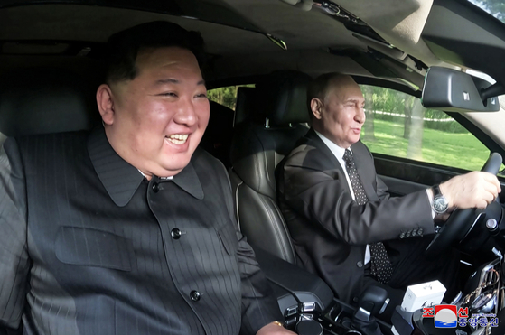 Russian President Vladimir Putin, right, drives North Korean leader Kim Jong-un in a Russian-made Aurus luxury limousine in Pyongyang on Wednesday, in a photo released by the North’s state-run Korean Central News Agency Thursday. They took turns driving the Aurus Putin gifted to Kim around the Kumsusan Guest House, the KCNA reported, and the North Korean leader praised the vehicle’s performance and expressed thanks for the car. [YONHAP]