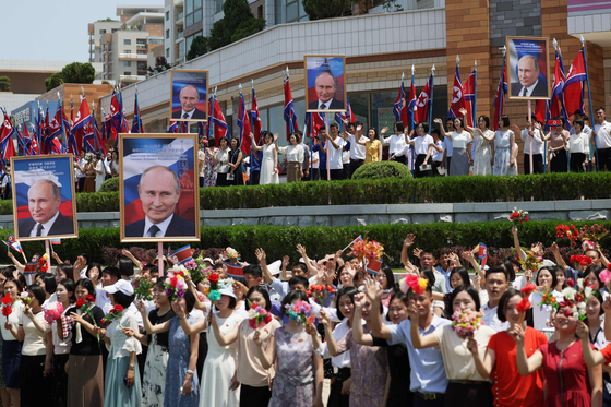 North Koreans wave to the motorcade during the welcoming ceremony for Russian President Vladimir Putin at Kim Il Sung Square in Pyongyang on Wednesday. [AFP/YONHAP]