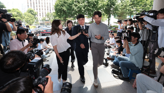 Lim Hyun-taek, center, president of the Korean Medical Association, attends a questioning on Thursday at the Seoul Metropolitan Policy Agency on the charges of inciting junior doctors to resign in February. [YONHAP]