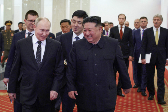 Russian President Vladimir Putin, left, and North Korean leader Kim Jong-un are all smiles as they attend a gala concert at a sports complex in Pyongyang on Wednesday. [AFP/YONHAP]