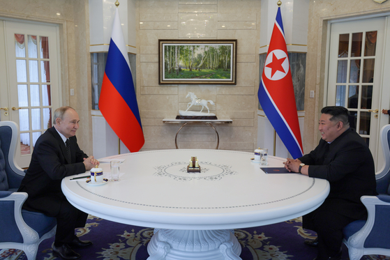 North Korean leader Kim Jong-un, right, Russian President Vladimir Putin hold a one-on-one meeting at the Kumsusan State Guest House in Pyongyang on Wednesday in a photo released by Russian state media. [AP/YONHAP]