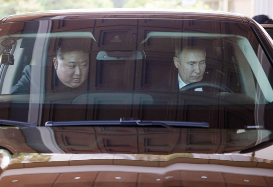 Russian President Vladimir Putin, left, and North Korean leader Kim Jong-un drive in a Russian-made Aurus luxury limousine in Pyongyang on Wednesday. [AFP/YONHAP]