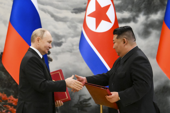 Russian President Vladimir Putin, left, and North Korean leader Kim Jong-un exchange documents during a signing ceremony in Pyongyang on Wednesday. [AP/YONHAP]