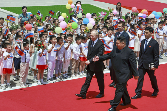 North Korean leader Kim Jong-un, front right, and Russian President Vladimir Putin take part in an official welcome ceremony in the Kim Il Sung Square in Pyongyang on Wednesday in a photo released by Russian state media. [AP/YONHAP]