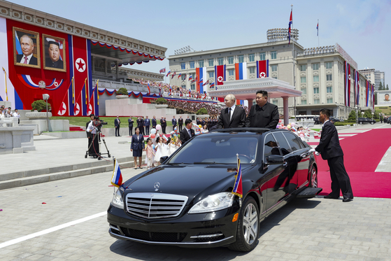 North Korean leader Kim Jong-un, right, Russian President Vladimir Putin arrive for an official welcoming ceremony at Kim Il Sung Square in Pyongyang Wednesday in a photo released by Russian state media. [AP/YONHAP]