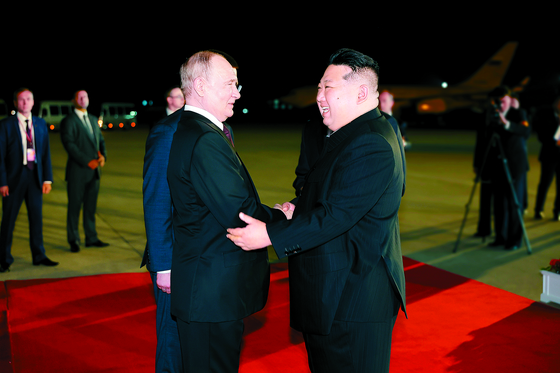 North Korean leader Kim Jong-un, right, greets Russian President Vladimir Putin at Sunan airport in Pyongyang early Wednesday in a photo carried by the North’s official Rodong Sinmun. [NEW1]