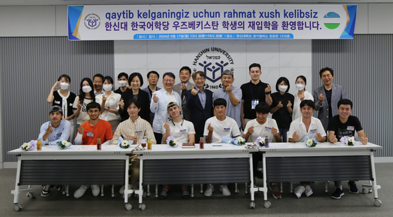 Eight Uzbekistan students that re-enrolled at Hanshin University pose for a photo with university officials during a welcoming ceremony held Monday. [HANSHIN UNIVERSITY]