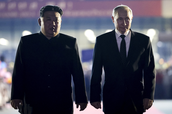 Russian President Vladimir Putin, right, and North Korea's leader Kim Jong-un stand together during the departure ceremony at Sunan Airport outside Pyongyang on Wednesday. [AP/YONHAP]