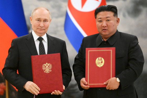 Russian President Vladimir Putin and North Korean leader Kim Jong-un pose for a photo during a signing ceremony following bilateral talks in Pyongyang on Wednesday. [REUTERS/YONHAP]