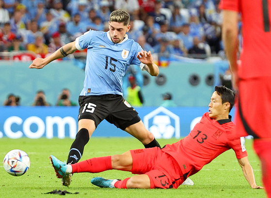 Korea's Son Jun-ho tackles Uruguay's Federico Valverde during a 2022 World Cup group stage match at Education City Stadium in Al Rayyan, Qatar on Nov. 25, 2022. [YONHAP] 