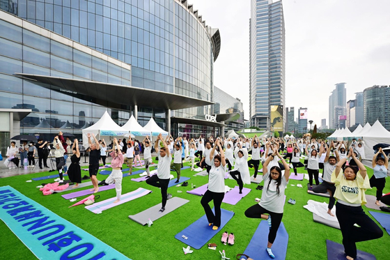 Participants practice yoga during an event celebrating the 10th International Day of Yoga at COEX Plaza in Gangnam District, southern Seoul, on Saturday. [EMBASSY OF INDIA]