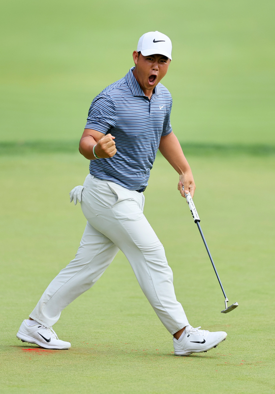 Tom Kim reacts to his putt on the 18th green to force a playoff during the final round of the Travelers Championship at TPC River Highlands in Cromwell, Connecticut on Sunday. [GETTY IMAGES]