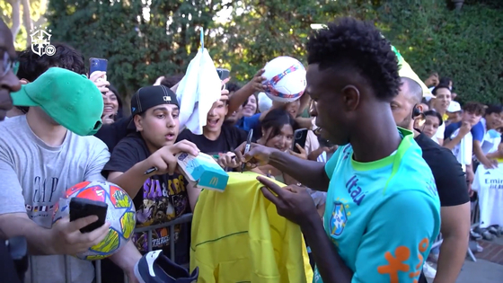  Vinicius JuniorBrazilan winger Vinicius Junior, right, signs his autograph for fans. [ONE FOOTBALL]