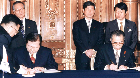 Former President Kim Dae-jung, front left, and former Japanese Prime Minister Keizo Obuchi sign the the New Korea-Japan Partnership towards the Twenty-first Century, which includes 11 articles addressing historical issues, on Oct. 8, 1998. Also known as the Kim-Obuchi Declaration, it was the first time a Japanese prime minister directly apologized to South Korea for causing harm and suffering to the people during the period of colonial rule. [KIM DAE-JUNG PRESIDENTIAL LIBRARY & MUSEUM]