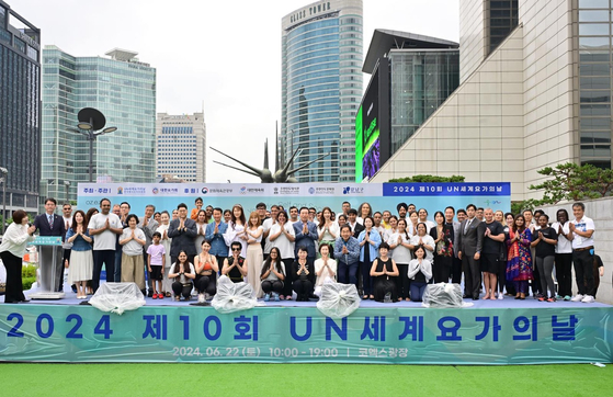 Participants and dignitaries pose for a photo during an event celebrating the 10th International Day of Yoga at COEX Plaza in Gangnam District, southern Seoul, on Saturday. [EMBASSY OF INDIA]