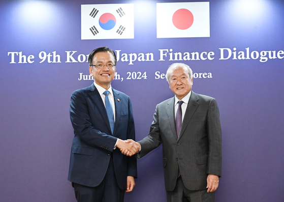 Korea’s Financial Minister Choi Sang-mok, left, and his Japanese counterpart Shunichi Suzuki pose for a photo during a bilateral economic ministerial meeting held in Seoul on Tuesday. [MINISTRY OF ECONOMY AND FINANCE]