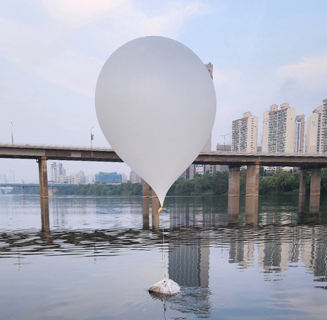 A balloon carrying trash, suspected to have been sent from North Korea, lands in the Han River near Jamsil Bridge in southern Seoul on June 9. [JOINT CHIEFS OF STAFF]