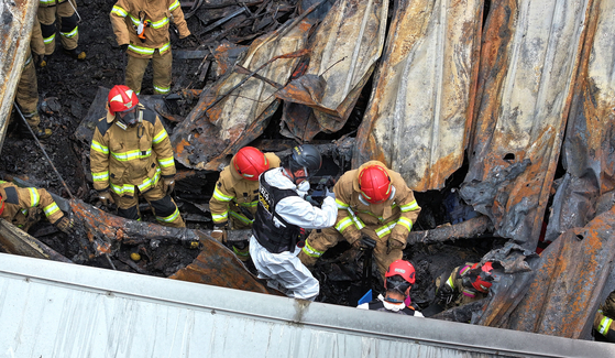 Firefighters and forensic workers conduct a joint investigation on Tuesday at a lithium battery plant in Hwaseong, Gyeonggi, where a fire broke out on Monday, resulting in 23 deaths. [JOONGANG ILBO]