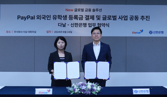 Danal CEO Baek Hyun-sook, left, and Shinhan Bank Digital Solution Group Vice President Lim Soo-han pose for a photo after signing the memorandum of understanding on Monday. [SHINHAN BANK]