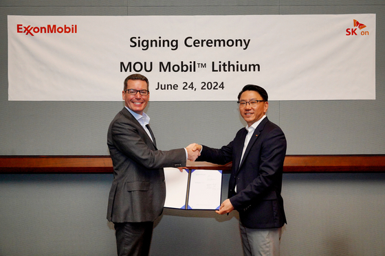 SK On's Park Jong-jin, vice president of strategic purchasing, left, and Dan Holton, senior vice president of Exxon Mobil’s low carbon solutions business, pose after signing a lithium supply deal at the Fastmarkets Lithium Supply and Battery Raw Materials Conference held at Las Vegas on Monday. [SK ON]