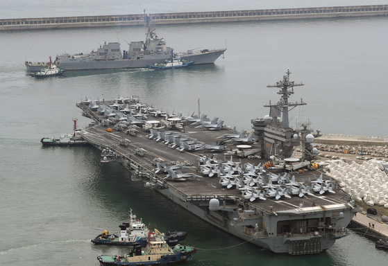 The Nimitz-class nuclear-powered aircraft carrier USS Theodore Roosevelt, right, begins to depart Busan on Wednesday to take part in Freedom Edge, a new trilateral multi-domain exercise involving South Korea, the United States and Japan. [NEWS1]