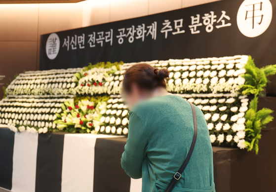 A family member of a victim of the battery factory fire in Hwaseong, shed tears at a memorial altar set up at Hwaseong City Hall on Wednesday. The fire, which broke out on Monday morning, resulted in 23 deaths. [YONHAP]
